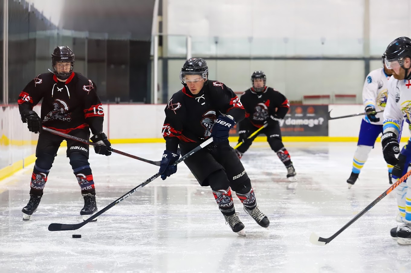 Chester Road Reapers players skating in black and red jerseys during a game